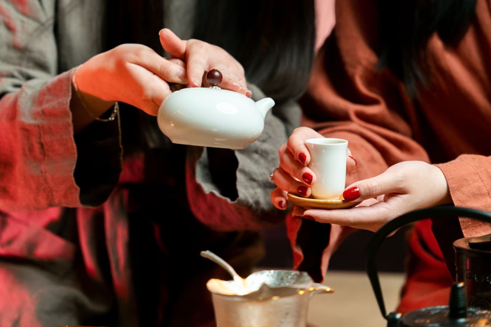 Tea poured from a porcelain pot into a small cup
